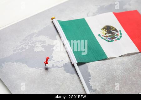 Weltkarte mit Pin und mexikanischer Flagge auf hellem Hintergrund, Nahaufnahme Stockfoto