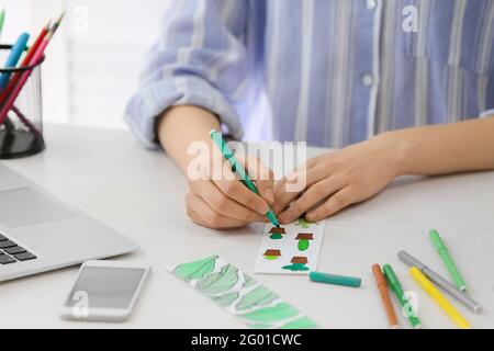 Frau Färbung Lesezeichen am Tisch Stockfoto