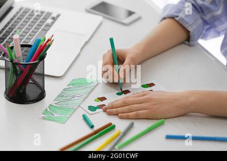 Frau Färbung Lesezeichen am Tisch Stockfoto