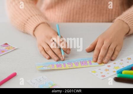 Frau Färbung Lesezeichen am Tisch Stockfoto