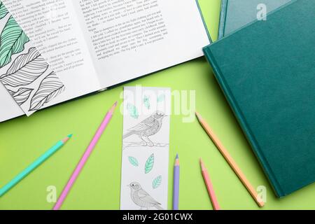 Niedliche Lesezeichen mit Büchern und Bleistiften auf farbigem Hintergrund Stockfoto
