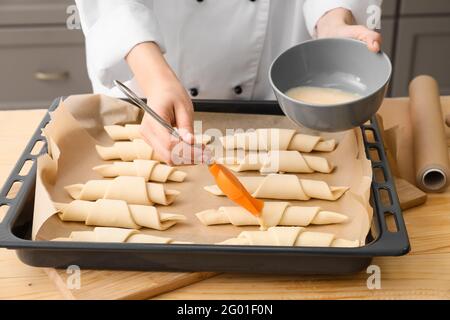 Frau kocht Croissants in der Küche, Nahaufnahme Stockfoto