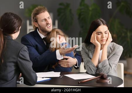 Das junge Paar und ihre Tochter besuchen den Scheidungsanwalt im Büro Stockfoto