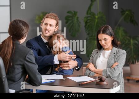 Das junge Paar und ihre Tochter besuchen den Scheidungsanwalt im Büro Stockfoto