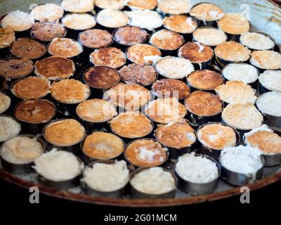 Khanom babin (thailändische Sprache). Köstliche Kokosnussmakronen oder Kokosnusspfannkuchen, traditionelle thailändische Dessertküche auf der großen runden Pfanne. Stockfoto