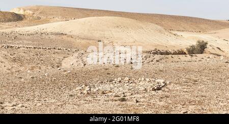 Ein kleiner alter Steinkreis und ein Wasserkanalsystem östlich Von Arad im Negev in Israel mit einem modernen Steinbruch im Hintergrund links Stockfoto