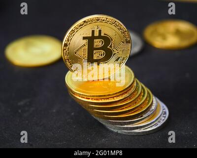 Stapel von Goldbitcoins auf einer schwarzen Oberfläche Stockfoto