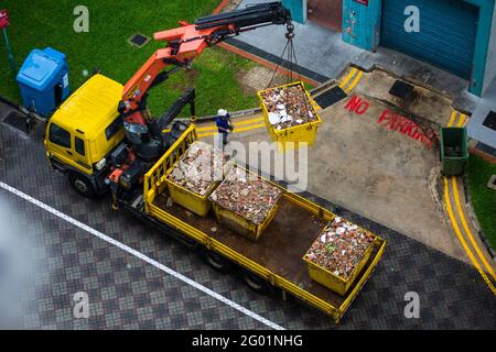 Luftaufnahme eines Bedieners, der den schweren Container mithilfe einer Technologie auf die Rückseite des Staplers hebt. Stockfoto