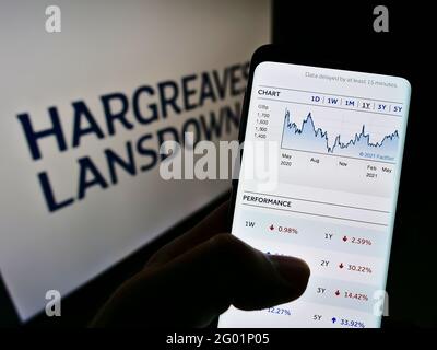 Person mit Mobiltelefon auf der Website des britischen Finanzunternehmens Hargreaves Lansdown plc auf dem Bildschirm mit Logo. Konzentrieren Sie sich auf die Mitte des Telefondisplays. Stockfoto