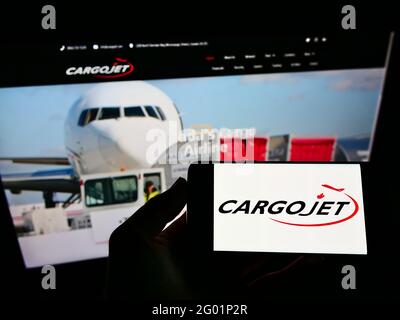 Person mit monbilem Telefon und Geschäftslogo der kanadischen Frachtfluggesellschaft Cargojet Inc. Auf dem Bildschirm vor der Webseite. Konzentrieren Sie sich auf die Telefonanzeige. Stockfoto