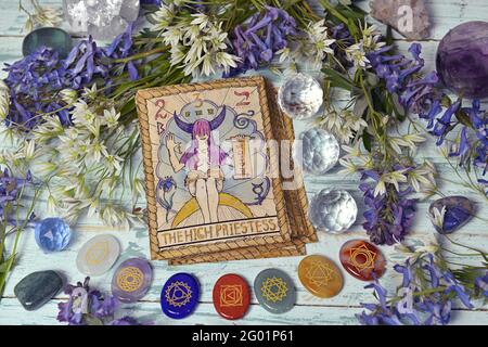 Stillleben mit hoher Priesterin-Karte des alten Tarot-Decks auf Hexenaltar-Tisch mit Chakra-Kristallen und Blumen. Esoterische, gotische und okkulte Backgroun Stockfoto