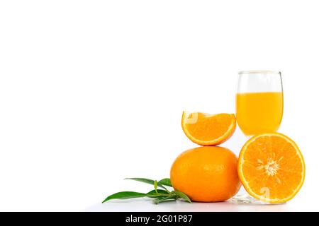 Frisch gepresster Orangensaft in einem Glas, das mit Zitrusfrüchten dekoriert ist Früchte und orangefarbene Blätter auf weißem Hintergrund mit Kopierfläche Stockfoto