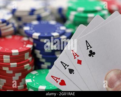 Vier Asse Karte Kombination holden vor dem gestapelten Casino Chips Stockfoto
