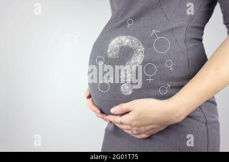 Nahaufnahme des Bauches einer Schwangeren mit Hologramm-Fragezeichen. Schwangerschaft, Mutterschaftskonzept. Stockfoto