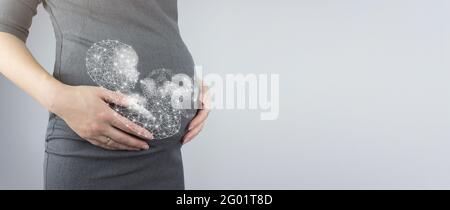 Nahaufnahme des Bauches einer Schwangeren mit Hologramm-fort. Schwangerschaft, Mutterschaftskonzept. Nahaufnahme, Kopierbereich. Stockfoto