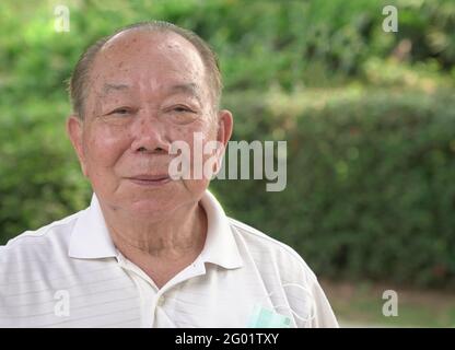 Porträt eines älteren asiatischen Mannes im Park. Nahaufnahme. Stockfoto