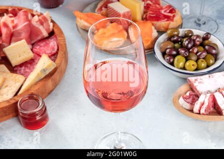 Roséwein und italienische Antipasti oder spanische Tapas in einer Bar. Blauschimmelkäse, Schinken aus Parmaschinken, Jamon, Oliven und Lachs-Sandwiches Stockfoto