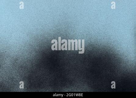 Schwarze Sprühfarbe auf blauem Papierhintergrund Stockfoto