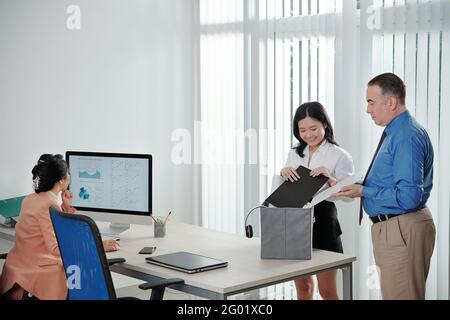 Die Personalmanagerin hilft neuen Mitarbeitern dabei, sie auszupacken Neuer Arbeitsplatz Stockfoto