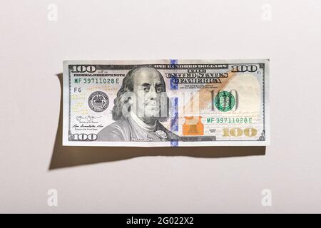 Grunge Overhead Detail einer 100 Dollar US-Banknote mit Schatten auf einem strukturierten weißen Hintergrund mit Rahmen und Copyspace Stockfoto