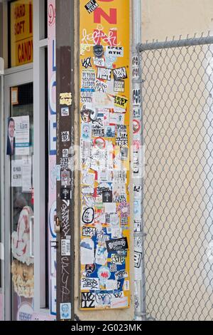 Eine Collage mit Graffiti, Aufklebern, Tags und Anzeigen in einem Geschäft auf der Surf Avenue in Coney Island, Brooklyn, New York City. Stockfoto