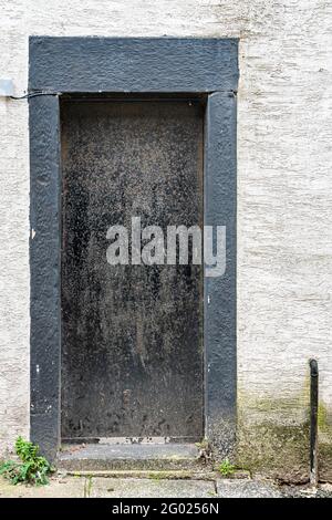 Schwarz lackierte Tür und Türrahmen gegen kontrastierende weiße Wände Stockfoto