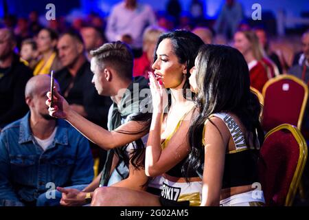 Ring Card Mädchen genießen ihre ringside Position, während der Kampf in auf und sie haben einen Moment, um sich selbst zu kümmern, bevor sie zurück zum Ring gehen Stockfoto