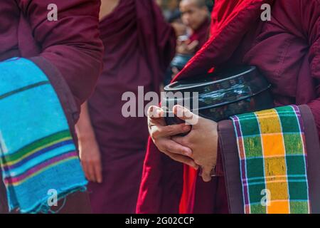 MANDALAY, MYANMAR - 30. DEZ 2017: Nahaufnahme des Mönchs, der mit einer traditionellen Schüssel im Mahagandayon Kloster in Myanmar wartet Stockfoto