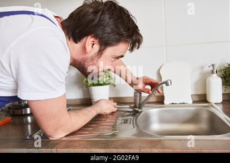 Heimwerker installieren einen Wasserhahn am Waschbecken in der Küche Stockfoto