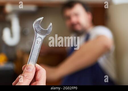 Die Hand hält den Schraubenschlüssel als Handwerkzeug für Installateur Und Montage Stockfoto