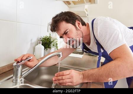 Handwerker oder Klempner überprüft Wasserhahn auf Küchenspüle nach der Reparatur Stockfoto