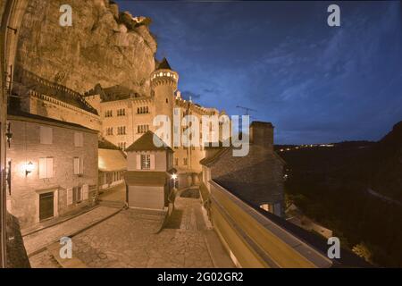 FRANKREICH - LOS - 46 - ROCAMADOUR : ZUGANG ZUR BASILIKA SAINT-SAUVEUR UND HEILIGTUM AUS DEM WESTEN IN DER ABENDDÄMMERUNG. RECHTS, DIE SPITZE DER GRAND STAIRCASE. M Stockfoto