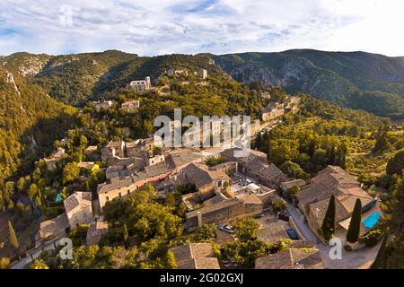 FRANKREICH - VAUCLUSE - 84 - OPPEDE LE VIEUX : PANORAMABLICK AUF DAS DORF AUS DEM NORDEN. IM VORDERGRUND DER DORFPLATZ, DER PETITONS MINGUETS Stockfoto