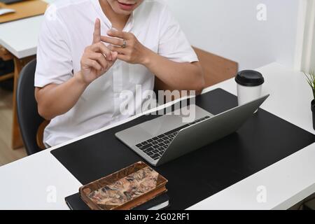 Kurzaufnahme eines Geschäftsmannes, der mit einem Geschäftspartner auf einem Laptop ein Videoanruf abgab. Stockfoto