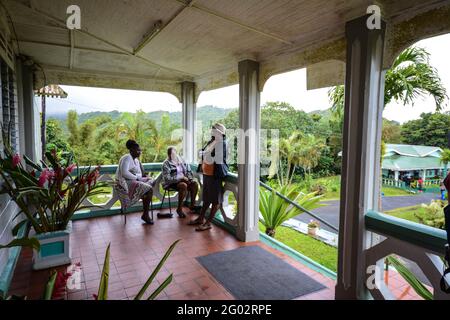 Palmen und Haus Carriacou Karibikinsel im alten Kolonialstil Blumen Pflanzen Blumen Blumen rote Säulen Säulenmatte Topf Deckenschiene Balkon Stockfoto