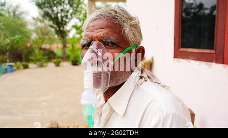 20. Mai 2021- Reengus, Sikar, Indien. Eine ältere Person, die sich mit der Covid-19-Krankheit infiziert hat. Patient inhaliert Sauerstoff mit Maske mit flüssigem Sauerstofffluss. Stockfoto