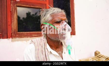 20. Mai 2021- Reengus, Sikar, Indien. Eine ältere Person, die sich mit der Covid-19-Krankheit infiziert hat. Patient inhaliert Sauerstoff mit Maske mit flüssigem Sauerstofffluss. Stockfoto