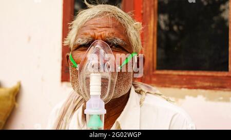 20. Mai 2021- Reengus, Sikar, Indien. Eine ältere Person, die sich mit der Covid-19-Krankheit infiziert hat. Patient inhaliert Sauerstoff mit Maske mit flüssigem Sauerstofffluss. Stockfoto