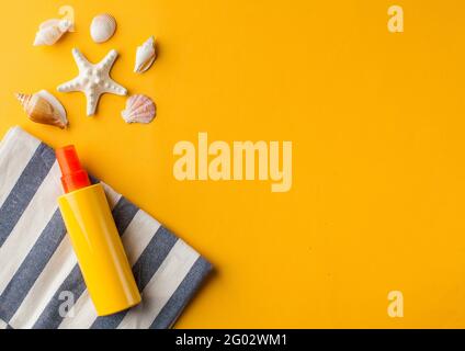 Summer background. Seashells, sunscreen on a yellow background. Copy space. Stockfoto