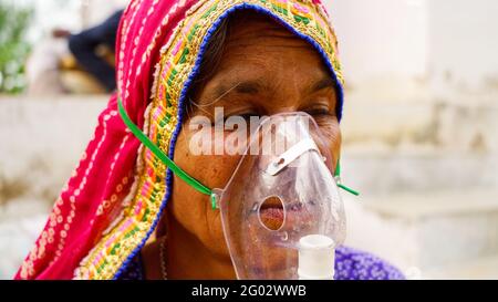 20. Mai 2021- Reengus, Sikar, Indien. Alte Inderin infiziert mit Covid 19 Krankheit. Patient inhaliert Sauerstoff mit Maske mit flüssigem Sauerstofffluss. Stockfoto