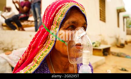 20. Mai 2021- Reengus, Sikar, Indien. Alte Inderin infiziert mit Covid 19 Krankheit. Patient inhaliert Sauerstoff mit Maske mit flüssigem Sauerstofffluss. Stockfoto