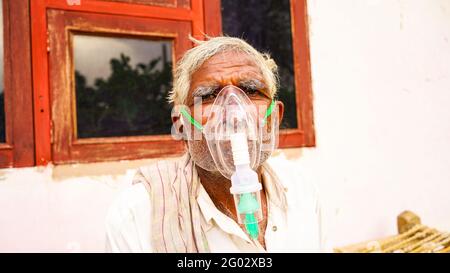 20. Mai 2021- Reengus, Sikar, Indien. Eine ältere Person, die sich mit der Covid-19-Krankheit infiziert hat. Patient inhaliert Sauerstoff mit Maske mit flüssigem Sauerstofffluss. Stockfoto