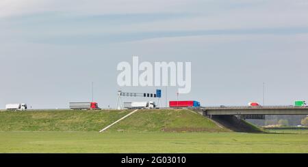 Reihe von Lastwagen, die Ladung auf der niederländischen Autobahn A1 in Deventer, Gelderland transportieren Stockfoto