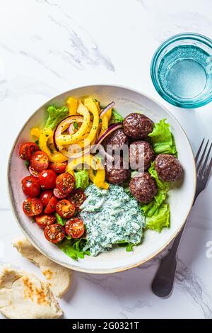 Griechisches Essenskonzept. Fleischbällchen, Tsatziki-Sauce, Tomaten- und Gurkensalat, Draufsicht. Stockfoto