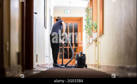 Hamburg, Deutschland. Mai 2021. Eine Frau saugt einen Flur in einem Hotel. Ab 01.06.2021 dürfen auch Hotels in Hamburg wieder Touristen empfangen, vorerst aber nur noch bei 60 Prozent ihrer Kapazität. Quelle: Daniel Reinhardt/dpa/Alamy Live News Stockfoto