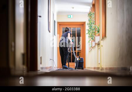 Hamburg, Deutschland. Mai 2021. Eine Frau saugt einen Flur in einem Hotel. Ab 01.06.2021 dürfen auch Hotels in Hamburg wieder Touristen empfangen, vorerst aber nur noch bei 60 Prozent ihrer Kapazität. Quelle: Daniel Reinhardt/dpa/Alamy Live News Stockfoto