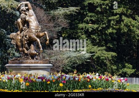 LYON, FRANKREICH, 8. April 2021 : Statue und Blumen im Parc de la Tete d'Or. Der Park ist einer der größeren Stadtparks in Frankreich. Stockfoto