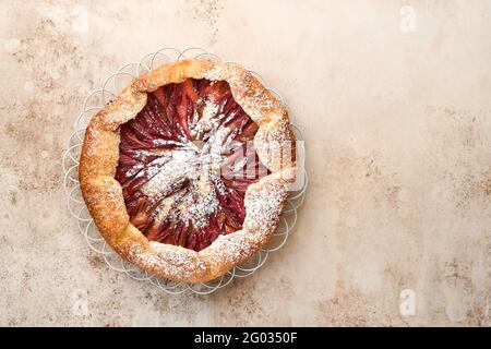 Hausgemachte Rhabarber-Galette mit Sternmuster auf altem Beton-Tischhintergrund. Backvorgang. Öffnen Sie die PIE. Weihnachten und Neujahr Backwaren. Bis Stockfoto