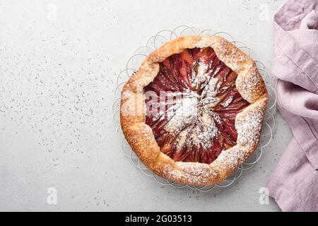 Hausgemachte Rhabarber-Galette mit Sternmuster auf altem Beton-Tischhintergrund. Backvorgang. Öffnen Sie die PIE. Weihnachten und Neujahr Backwaren. Bis Stockfoto