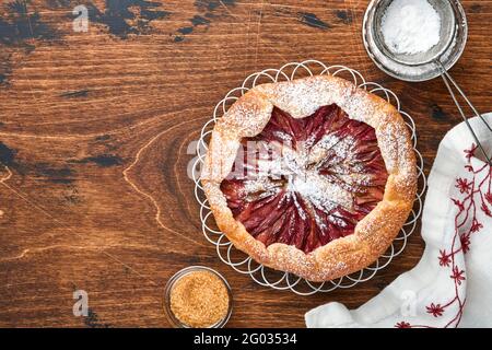 Hausgemachte Rhabarber-Galette mit Sternmuster auf altem Holztisch-Hintergrund. Backvorgang. Öffnen Sie die PIE. Weihnachten und Neujahr Backwaren. Oben Stockfoto